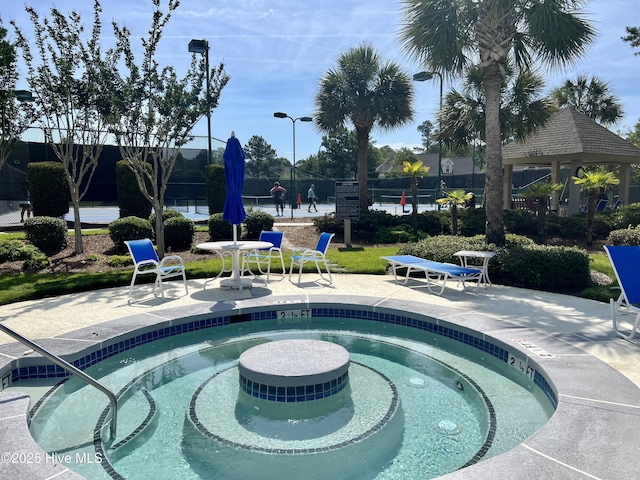 view of swimming pool with a hot tub and a patio