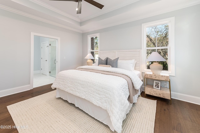 bedroom with a tray ceiling, crown molding, dark wood-type flooring, and ceiling fan