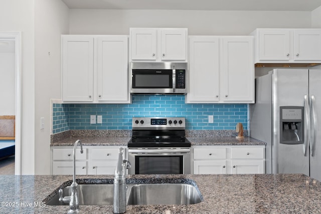 kitchen featuring white cabinetry, stainless steel appliances, and decorative backsplash