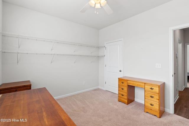 unfurnished office featuring carpet floors, baseboards, and a ceiling fan