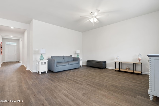 living area featuring a ceiling fan, baseboards, and wood finished floors