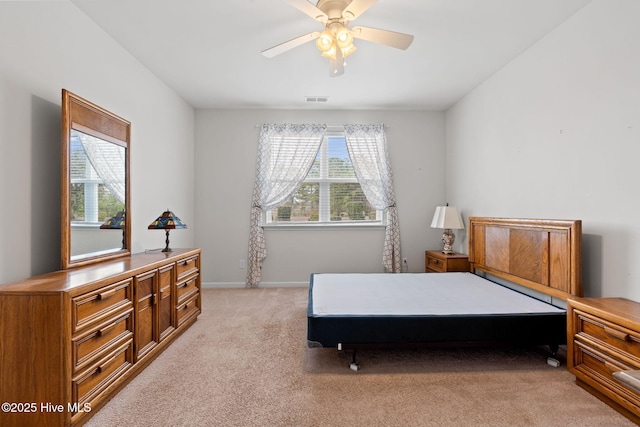 bedroom with baseboards, visible vents, and light colored carpet