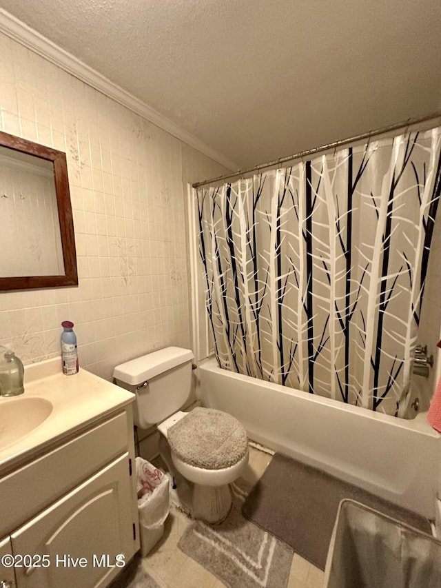 full bathroom with shower / tub combo with curtain, a textured ceiling, tile walls, ornamental molding, and vanity