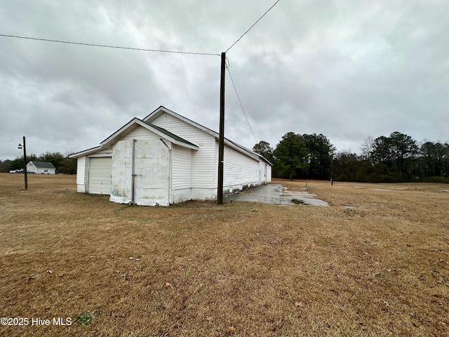 view of side of property with a garage and a lawn