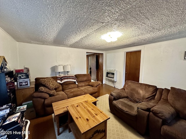 living room featuring heating unit, hardwood / wood-style flooring, and a textured ceiling