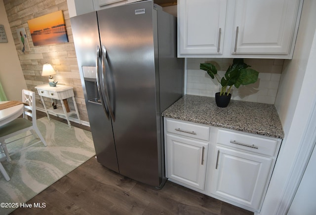 kitchen featuring decorative backsplash, dark wood-type flooring, light stone countertops, white cabinetry, and stainless steel refrigerator with ice dispenser