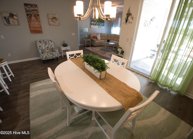 dining room featuring a chandelier, dark wood-type flooring, and baseboards