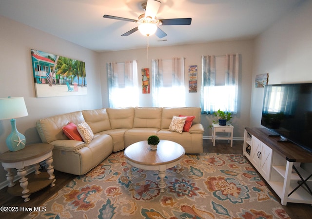 living room featuring wood finished floors, a ceiling fan, and baseboards