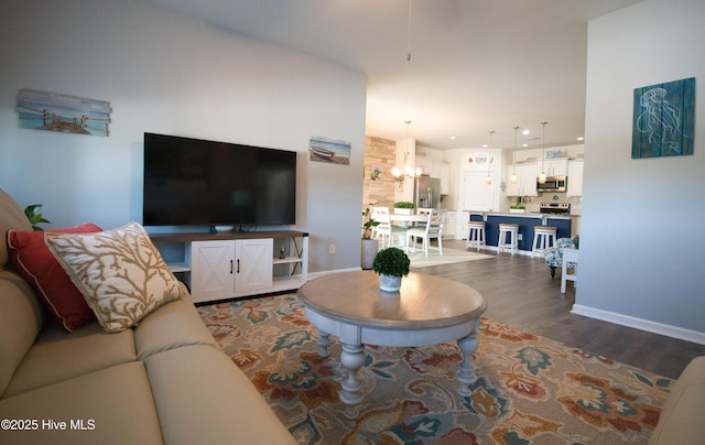 living area featuring recessed lighting, dark wood-style flooring, an inviting chandelier, and baseboards