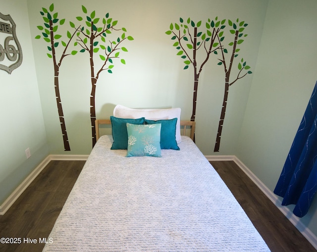 bedroom with dark wood-style floors and baseboards