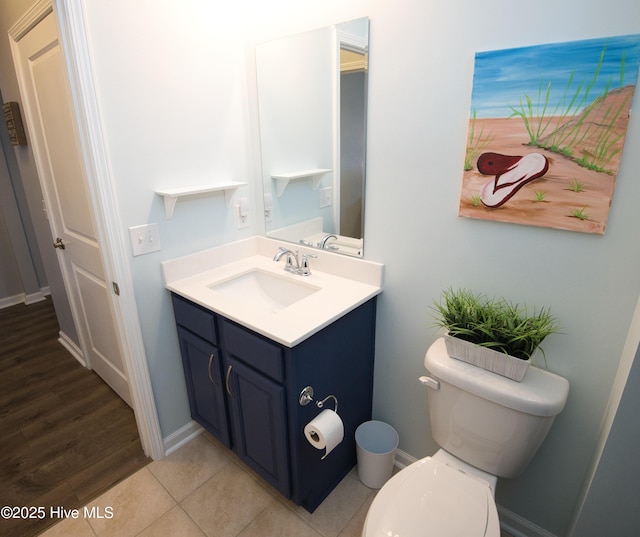 bathroom featuring tile patterned floors, vanity, toilet, and baseboards