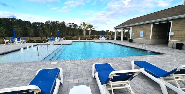 pool with a patio and fence