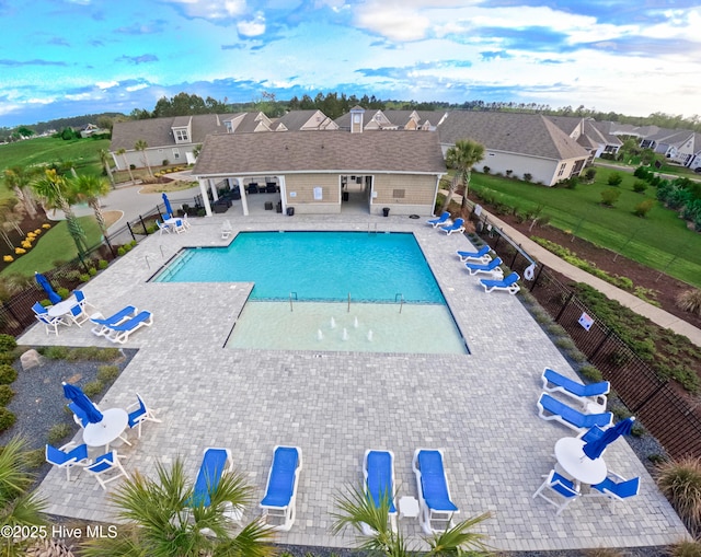 community pool featuring a residential view, a patio area, and fence