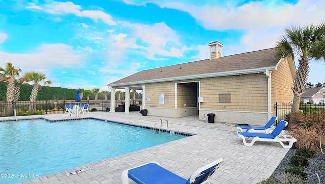 pool with a patio and fence