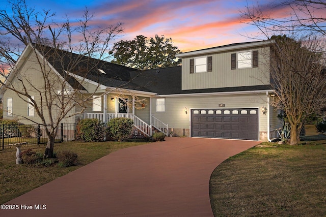 traditional home featuring covered porch, driveway, a lawn, and fence