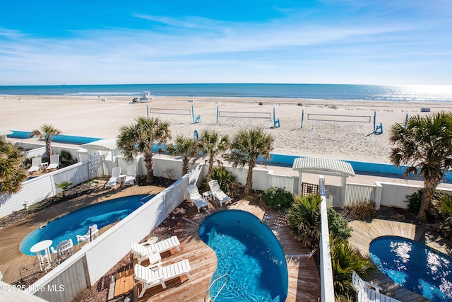 view of pool with a view of the beach, a water view, and a water slide