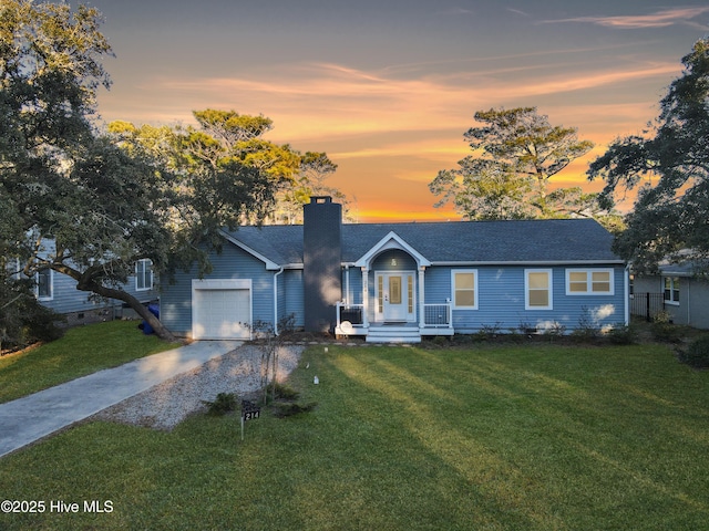 single story home with a garage and a lawn