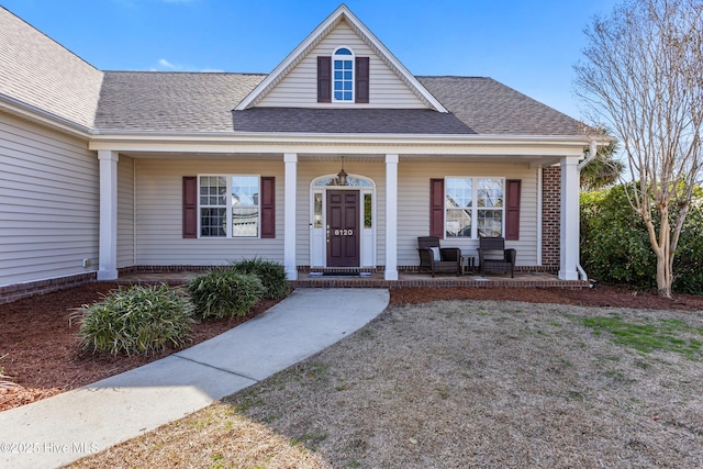 view of front of property with a shingled roof and a porch