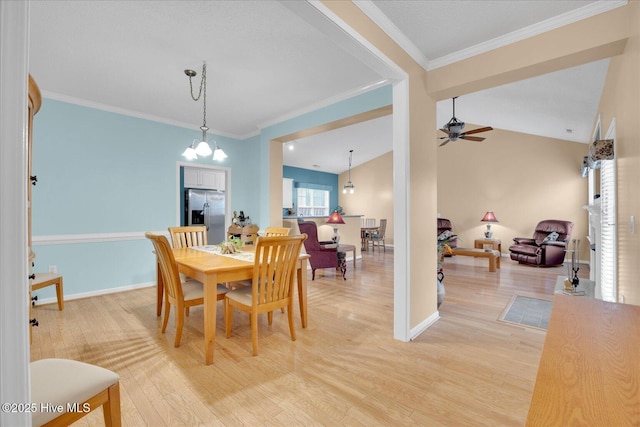 dining space featuring lofted ceiling, crown molding, wood-type flooring, and ceiling fan