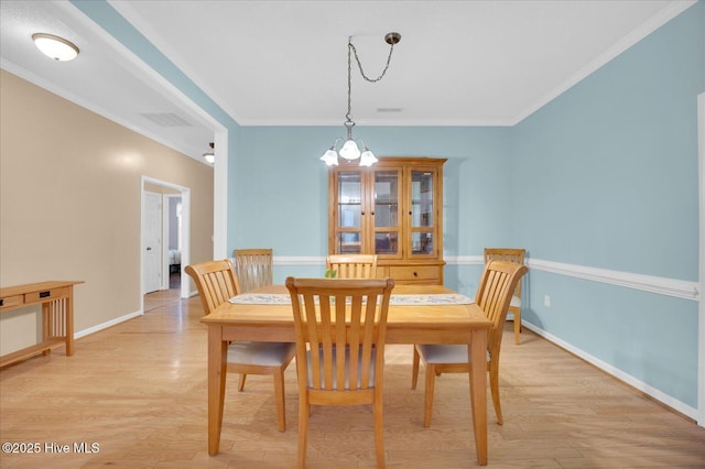 dining space with ornamental molding and light wood-type flooring