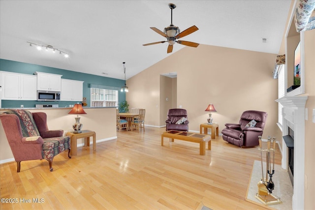 living room with ceiling fan, high vaulted ceiling, and light hardwood / wood-style floors