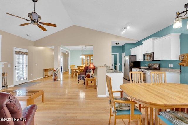 dining area with ceiling fan, high vaulted ceiling, and light hardwood / wood-style floors