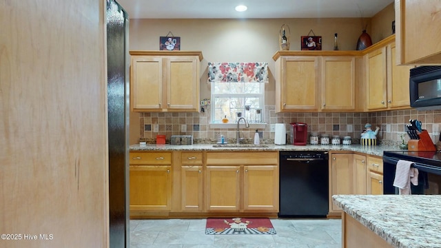 kitchen featuring sink, backsplash, light stone counters, and black appliances