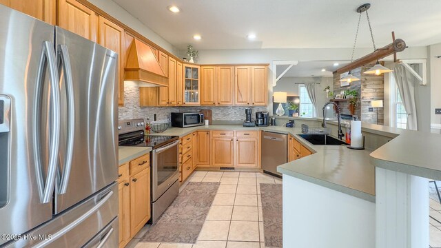 kitchen with pendant lighting, light countertops, a sink, and stainless steel dishwasher