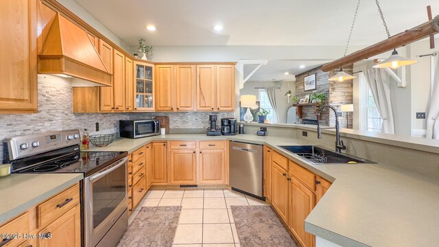 kitchen with light countertops, light tile patterned flooring, a sink, and hanging light fixtures