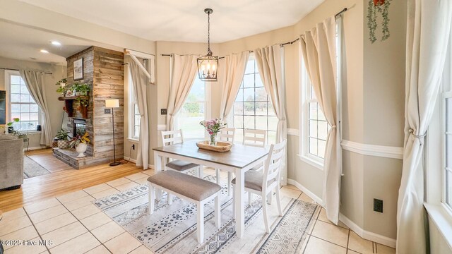 interior space with a ceiling fan, light tile patterned flooring, and baseboards