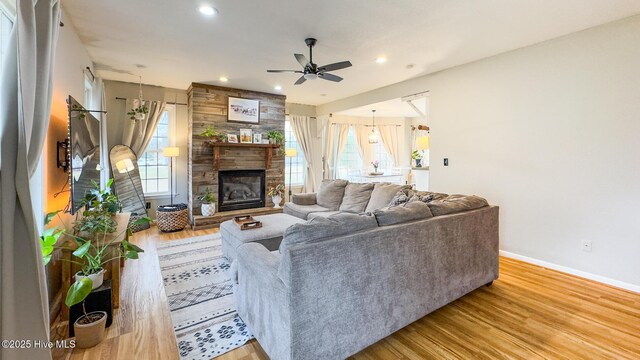 living room with ceiling fan, recessed lighting, light wood-type flooring, and baseboards