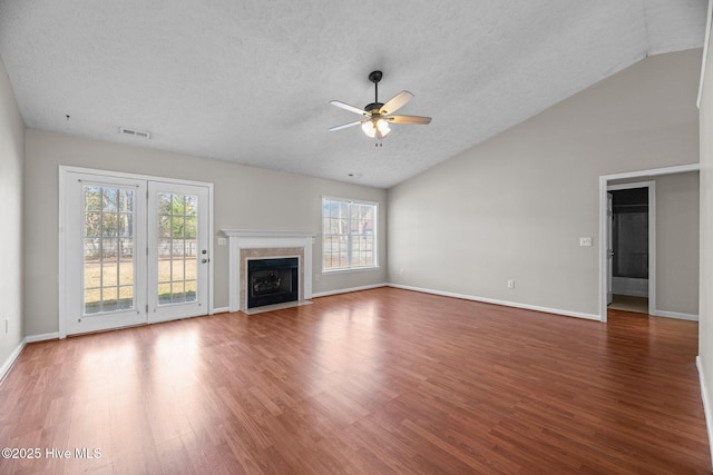 unfurnished living room featuring hardwood / wood-style floors, lofted ceiling, a premium fireplace, a textured ceiling, and ceiling fan