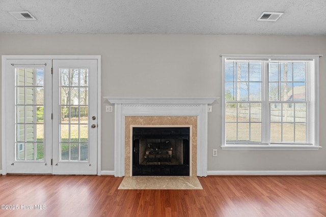 unfurnished living room featuring light hardwood / wood-style flooring, plenty of natural light, and a textured ceiling