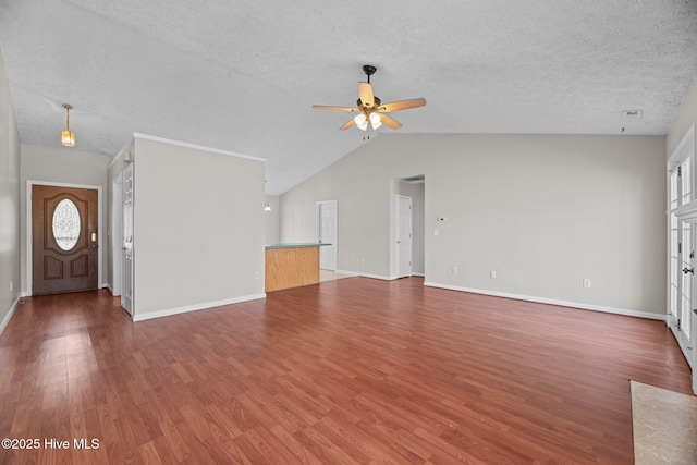 unfurnished living room with ceiling fan, lofted ceiling, wood-type flooring, and a textured ceiling