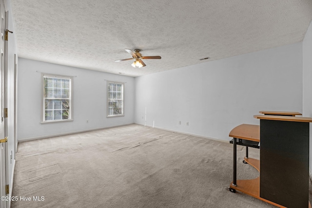 carpeted spare room with ceiling fan and a textured ceiling