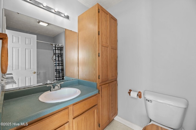 bathroom featuring toilet, vanity, and a shower with curtain