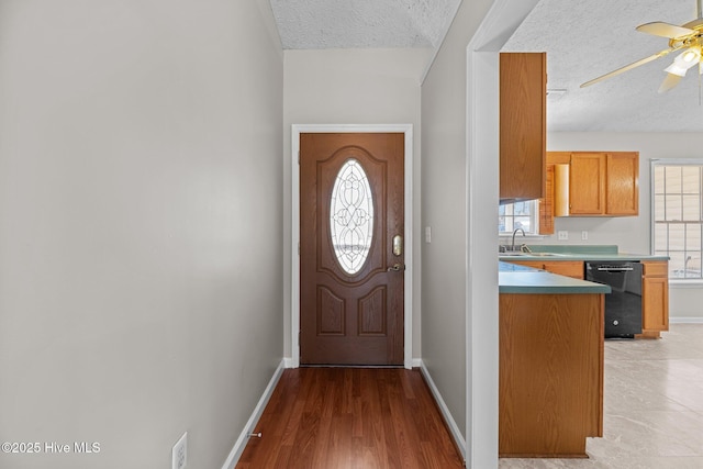 doorway to outside with sink, ceiling fan, a textured ceiling, and plenty of natural light