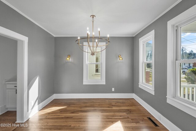 unfurnished dining area with crown molding, dark wood-style flooring, visible vents, and baseboards
