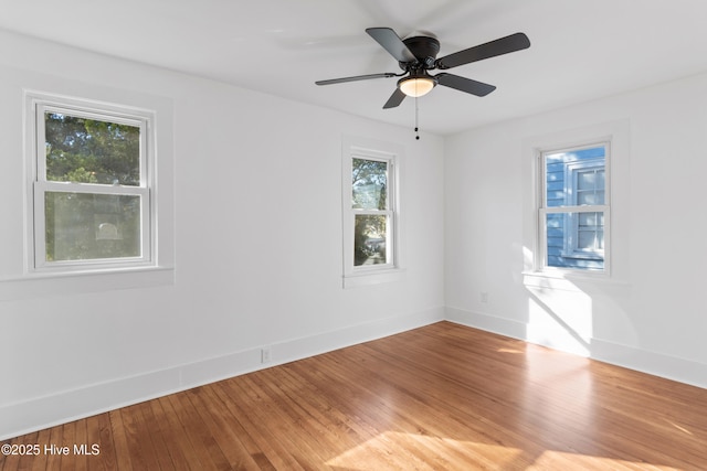 unfurnished room featuring a ceiling fan, baseboards, and wood finished floors