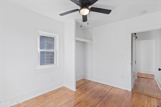 unfurnished bedroom with a ceiling fan, a closet, baseboards, and wood finished floors