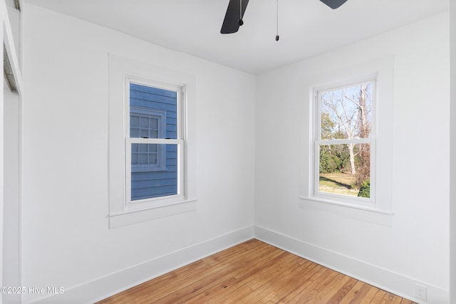 empty room with a ceiling fan, baseboards, and wood finished floors