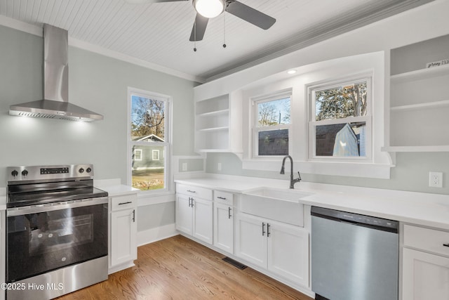 kitchen featuring open shelves, light countertops, appliances with stainless steel finishes, white cabinetry, and wall chimney range hood
