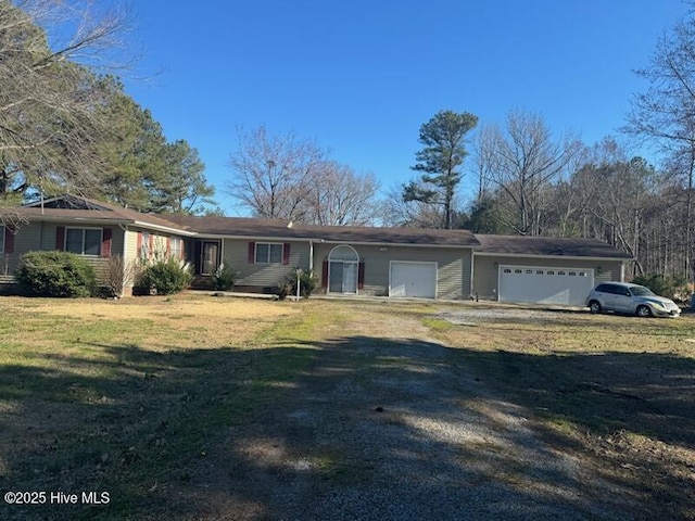 single story home with a garage, dirt driveway, and a front lawn