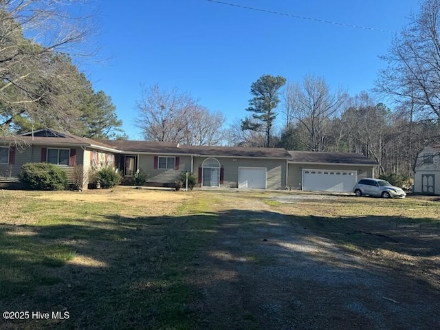 single story home with a garage, dirt driveway, and a front lawn