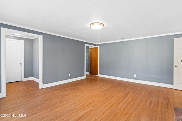 spare room with crown molding and light wood-type flooring