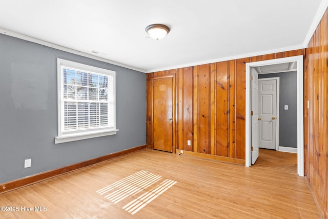 unfurnished bedroom featuring ornamental molding and light wood-type flooring