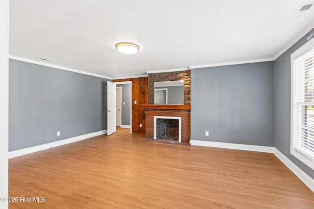 unfurnished living room with ornamental molding, light wood-type flooring, and a fireplace