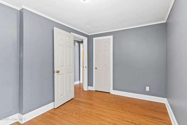 unfurnished room with ornamental molding and light wood-type flooring