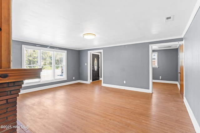 unfurnished living room with crown molding and light hardwood / wood-style flooring