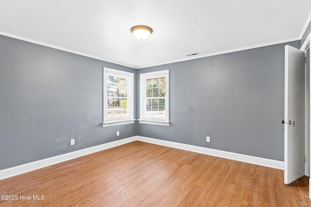 spare room featuring crown molding and hardwood / wood-style floors